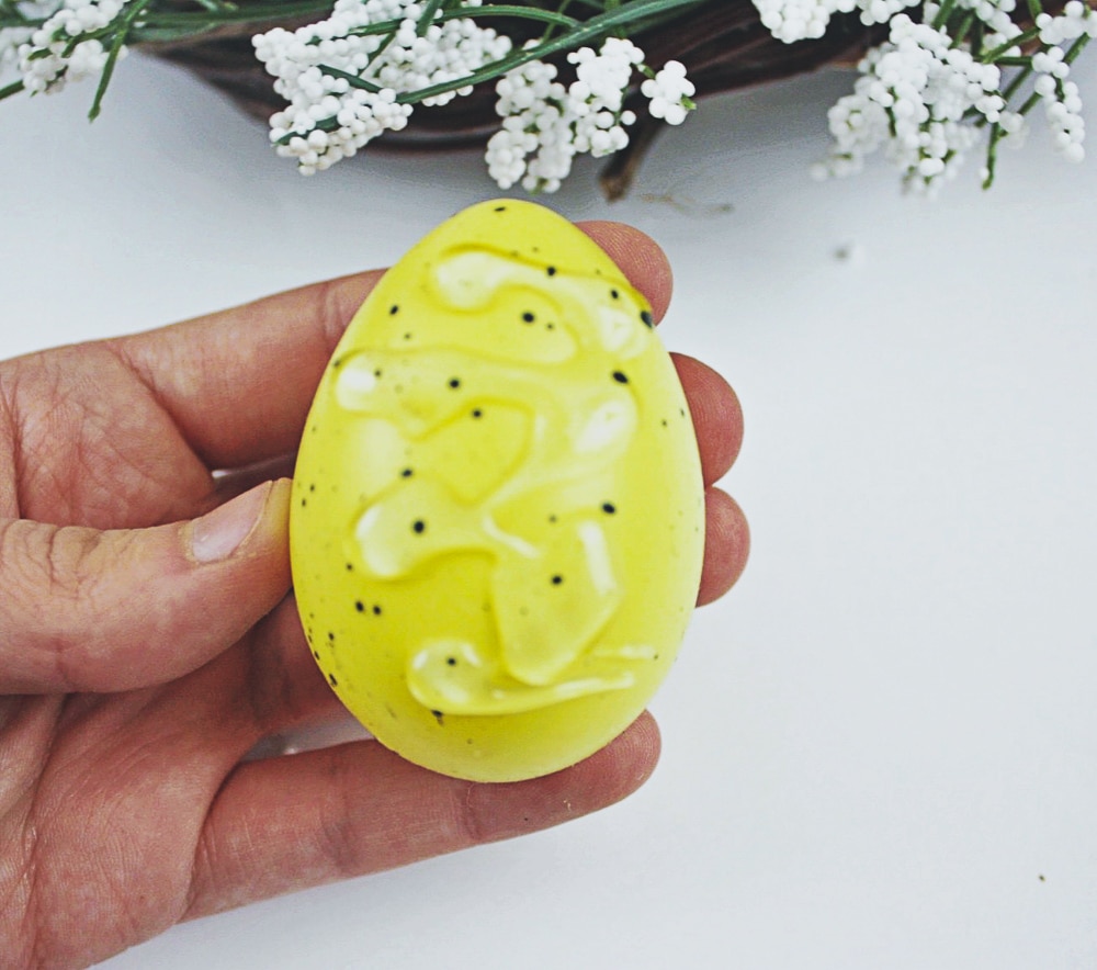 Gluing on your easter eggs to make your own easter themed wreathe.
