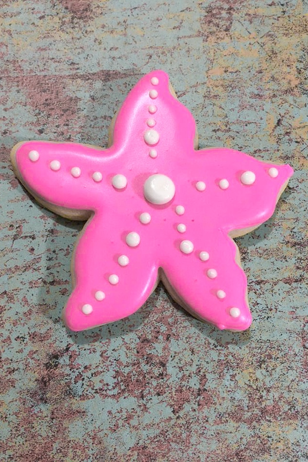 piping dots onto mermaid themed starfish cookies