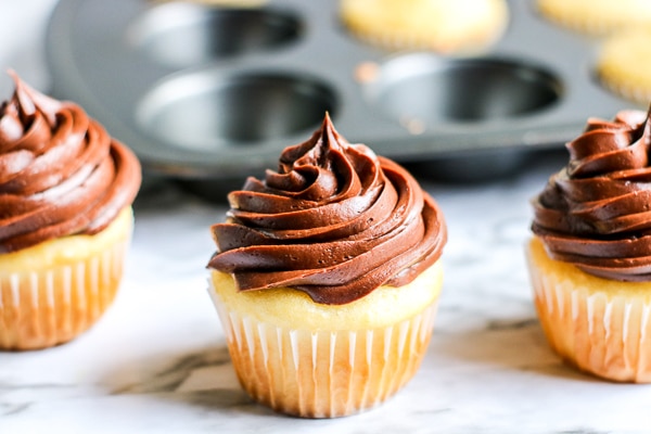 Icing cupcakes with chocolate icing for reindeer cupcake recipe