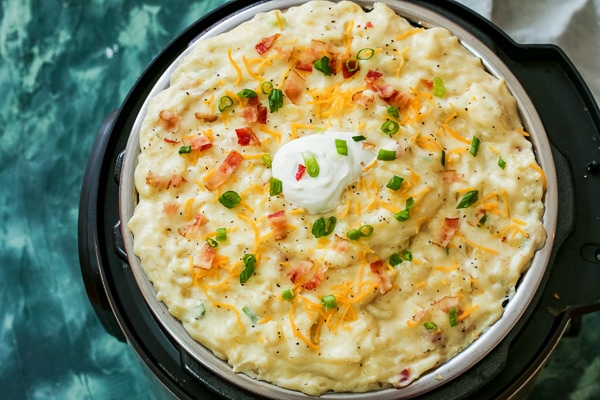 Instant pot filled with mashed potatoes, bacon and loaded with toppings