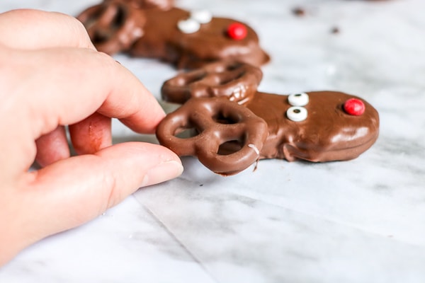 assembling reindeer and rudolph from pretzels and nutter butters